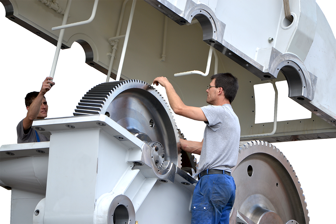 Zwei Monteure der Firma KACHELMANN GETRIEBE GmbH arbeiten während das Getriebe verladen wird, an einem Sondergetriebe, welches eine hellgraue Farbe hat. KACHELMANN GETRIEBE GmbH