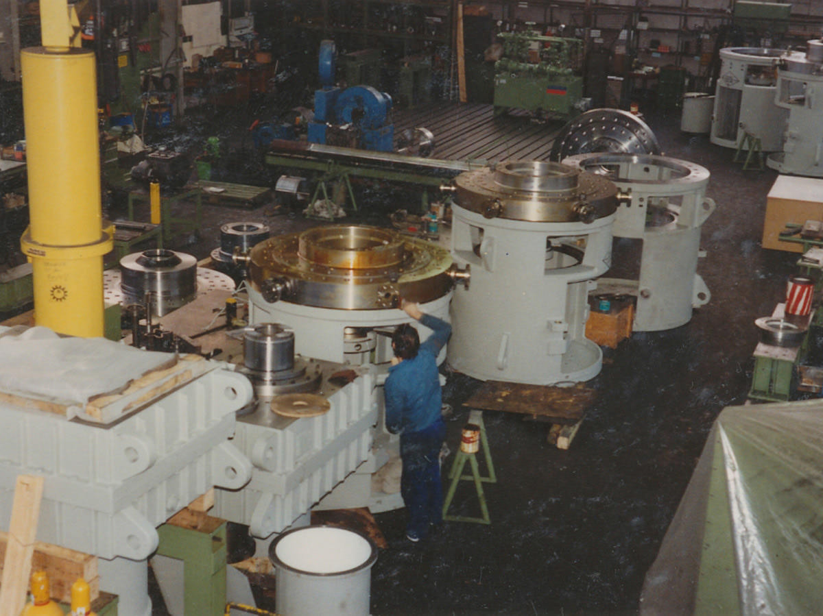 In der Werkshalle in Strullendorf werden viele Getriebe gebaut, modernisiert und gefertigt. Das Bild zeigt im Jahr 1989 einen Arbeiter, der vor einem Getriebe steht und daran arbeitet. KACHELMANN GETRIEBE GmbH