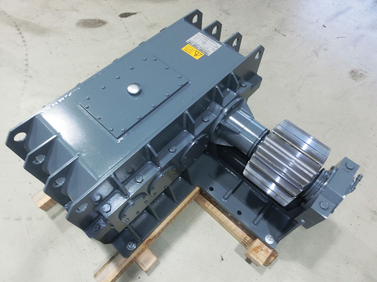 In der Fertigungshalle der Firma KACHELMANN GETRIEBE GmbH werden Einzelteile für unterschiedlichste Getriebetypen produziert. Sie liegen auf dem Tisch. Im Hintergrund befindet sich ein Ausschnitt eines weißen Getriebes auf Paletten. KACHELMANN GETRIEBE GmbH