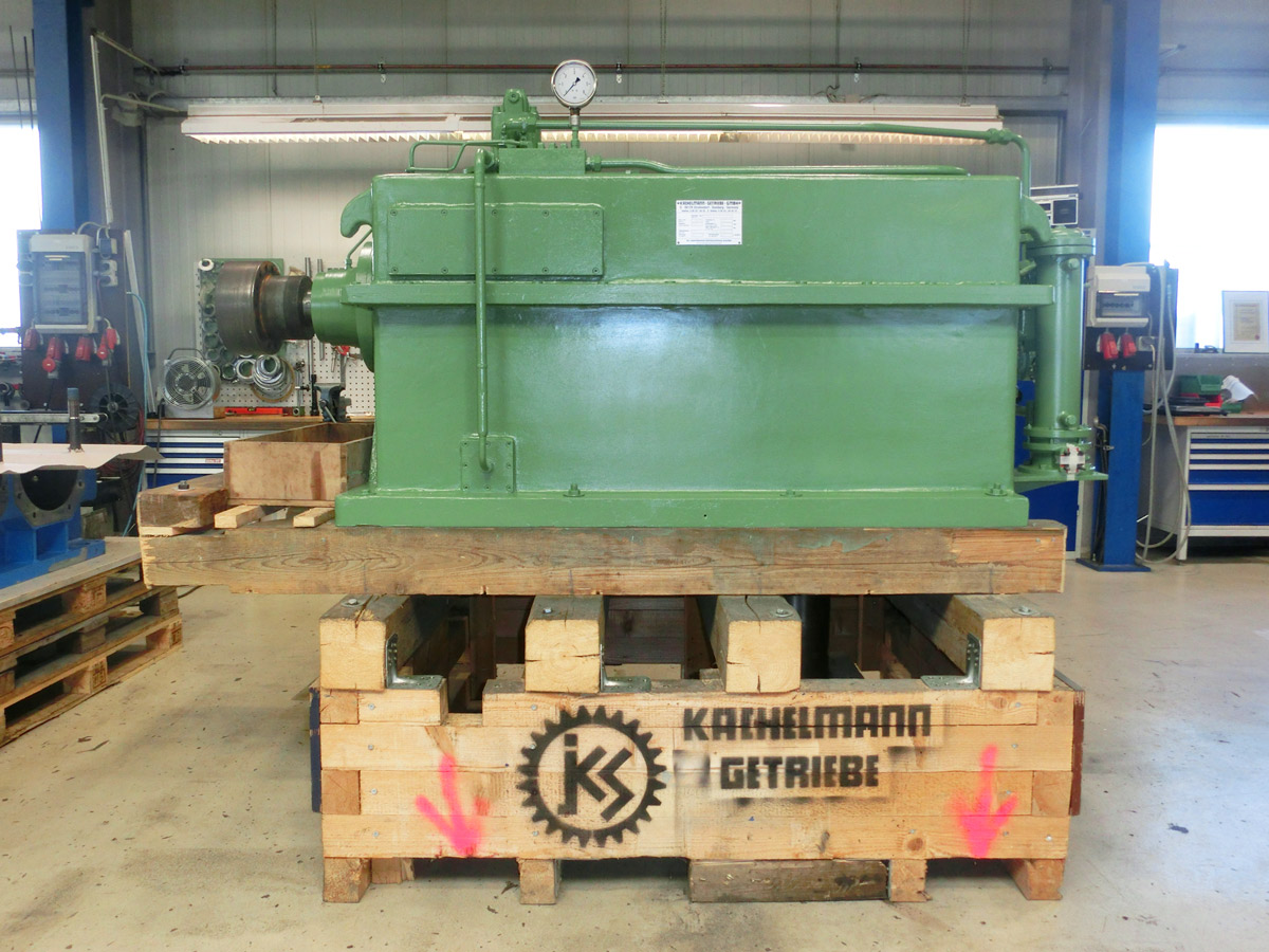 In der Fertigungshalle der Firma KACHELMANN GETRIEBE GmbH wird das Kegelstirnradgetriebe gefertigt. Das Sondergetriebe ist grün und steht auf einer Palette. KACHELMANN GETRIEBE GmbH